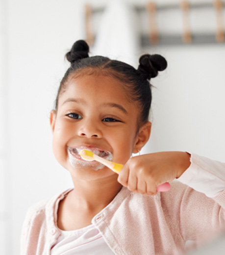 Young girl brushing her teeth in bathroom