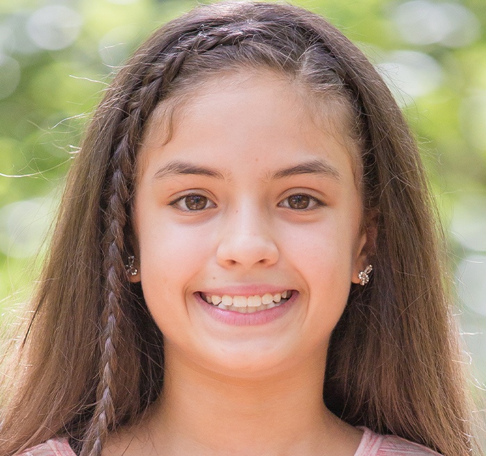 Preteen girl with clear aligners smiling