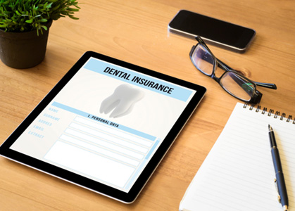 Dental insurance form displayed on electronic tablet sitting on desk