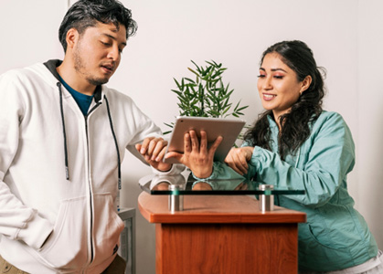Dental team member and patient talking at front desk