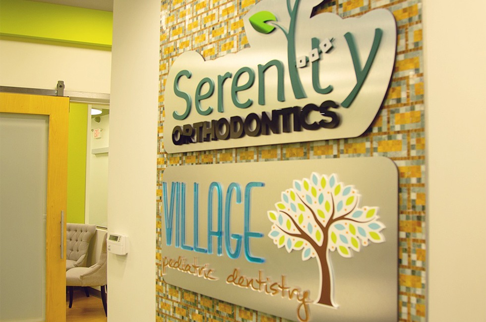 Serenity Orthodontics and Village Pediatric Dentistry signs in office entryway