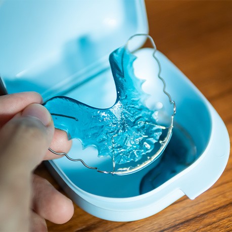 Patient placing blue retainer in blue case