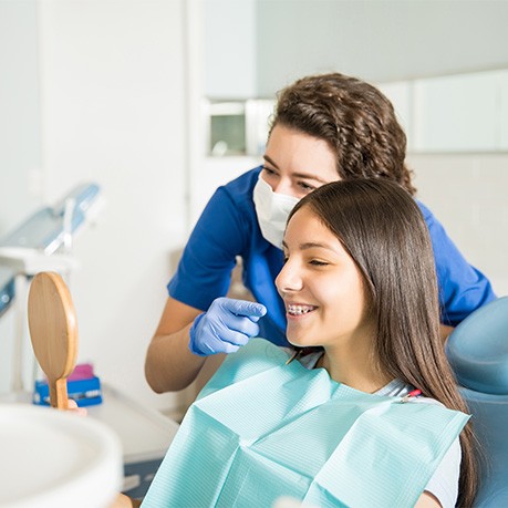 Patient with braces looking at smile in reflection