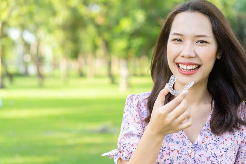 young woman holding clear aligner