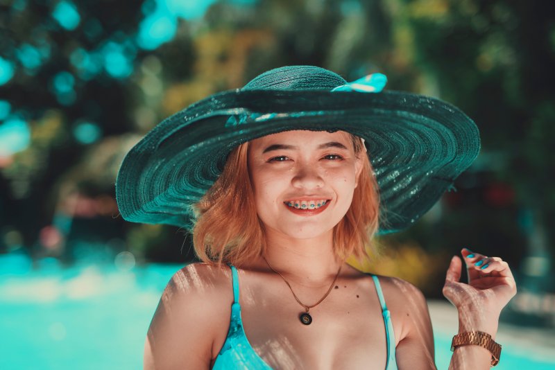 Lady with braces smiles by pool